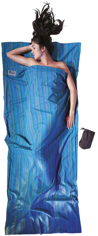 Housse de lit zippée en coton de Cocoon - bleu - Mise en situation : une personne dort dans la housse de lit avec la pochette posée à côté, utilisée en version simple