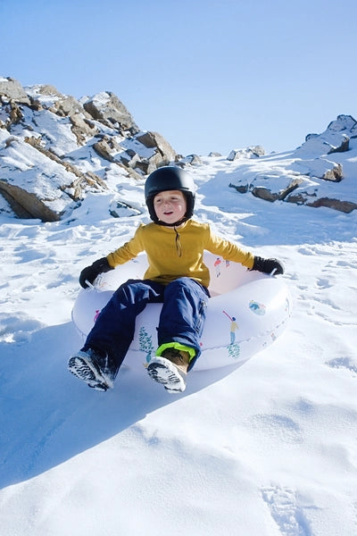 Luge gonflable The Nice Fleet modèle ASPEN - Mise en situation de la luge glissant sur la neige avec en enfant