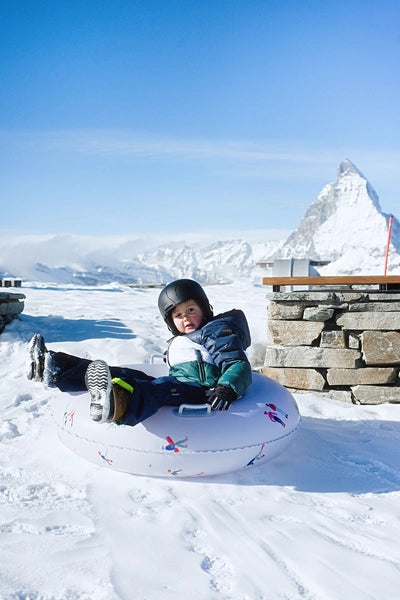 Luge gonflable The Nice Fleet modèle ASPEN - mise en situation de la luge glissant sur la neige avec un enfant dessus