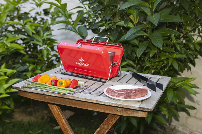 Barbecue à charbon pliable portatif de kikirikit rouge - Mise en situation sur une table avec des aliments