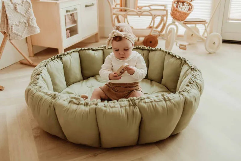 Tapis d’éveil 3-en-1 Bloom de Play and Go – couleur vert prairie – vue du tapis en version cocon avec un enfant qui y joue