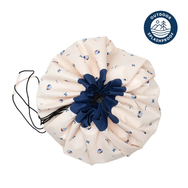 Tapis de jeu et sac de rangement d’extérieur Play and Go – motif ballons – vue du sac en version rangement – écusson “outdoor splashproof” visible sur la photo