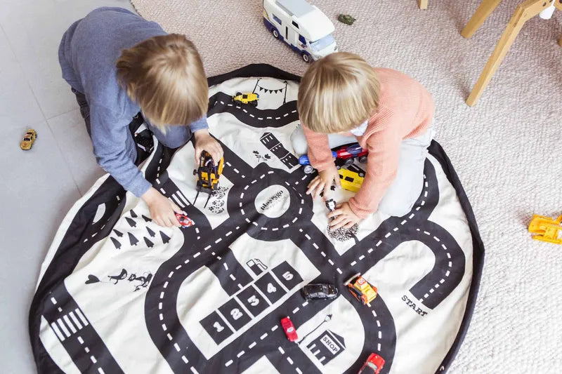Sac de rangement et tapis de jeu Play and Go – motif circuit de voitures – mise en situation du tapis avec deux enfants qui jouent aux voitures