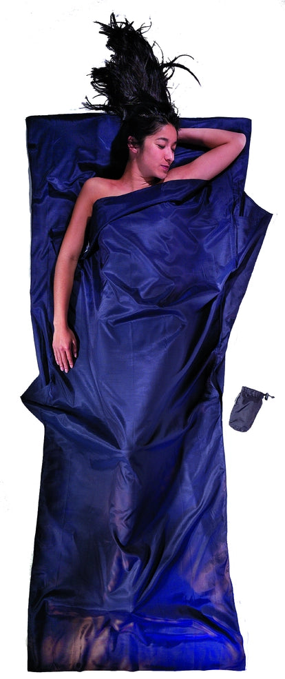 Housse de lit adulte en coton et soie Cocoon - Marine - mise en situation : une personne dort dans le drap, la pochette placée juste à côté.