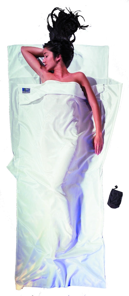 Housse de lit adulte en coton et soie Cocoon - Blanc - mise en situation : une personne dort dans le drap, la pochette placée juste à côté.