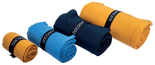 Serviette de voyage ultralégère Cocoon – vue roulé des 3 coloris (marine, orange et bleu) et des 4 tailles (S, M, L et XL).