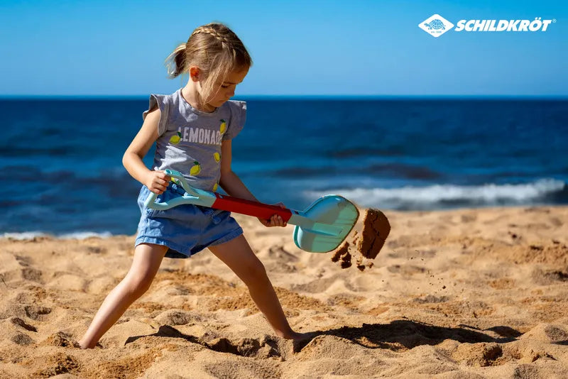Set de plage 2-en-1 épuisette et pelle de Schildkröt - mise en situation d'une petite fille utilisant la pelle sur la plage