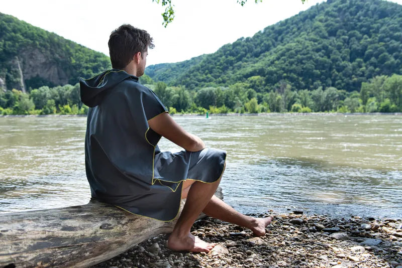 Poncho-serviette unisexe de Cocoon - vue de dos, porté par un homme devant un lac