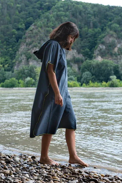 Poncho-serviette unisexe de Cocoon - vue de profil, porté par une dame devant un lac