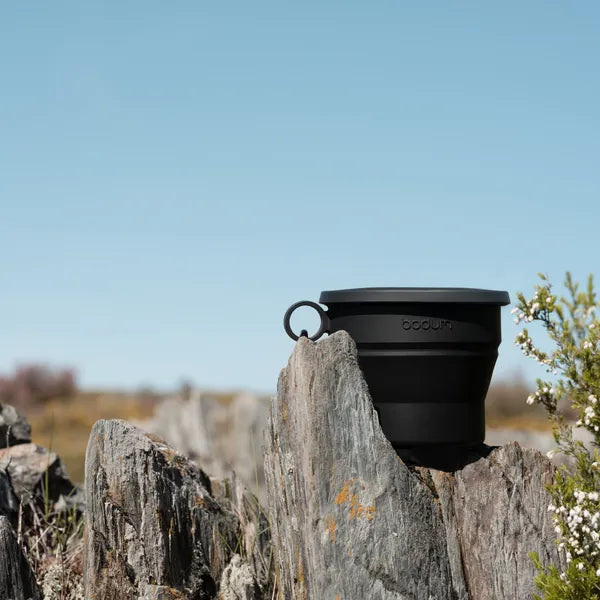 Tasse pliable noire de Bodum - mise en situation sur un rocher