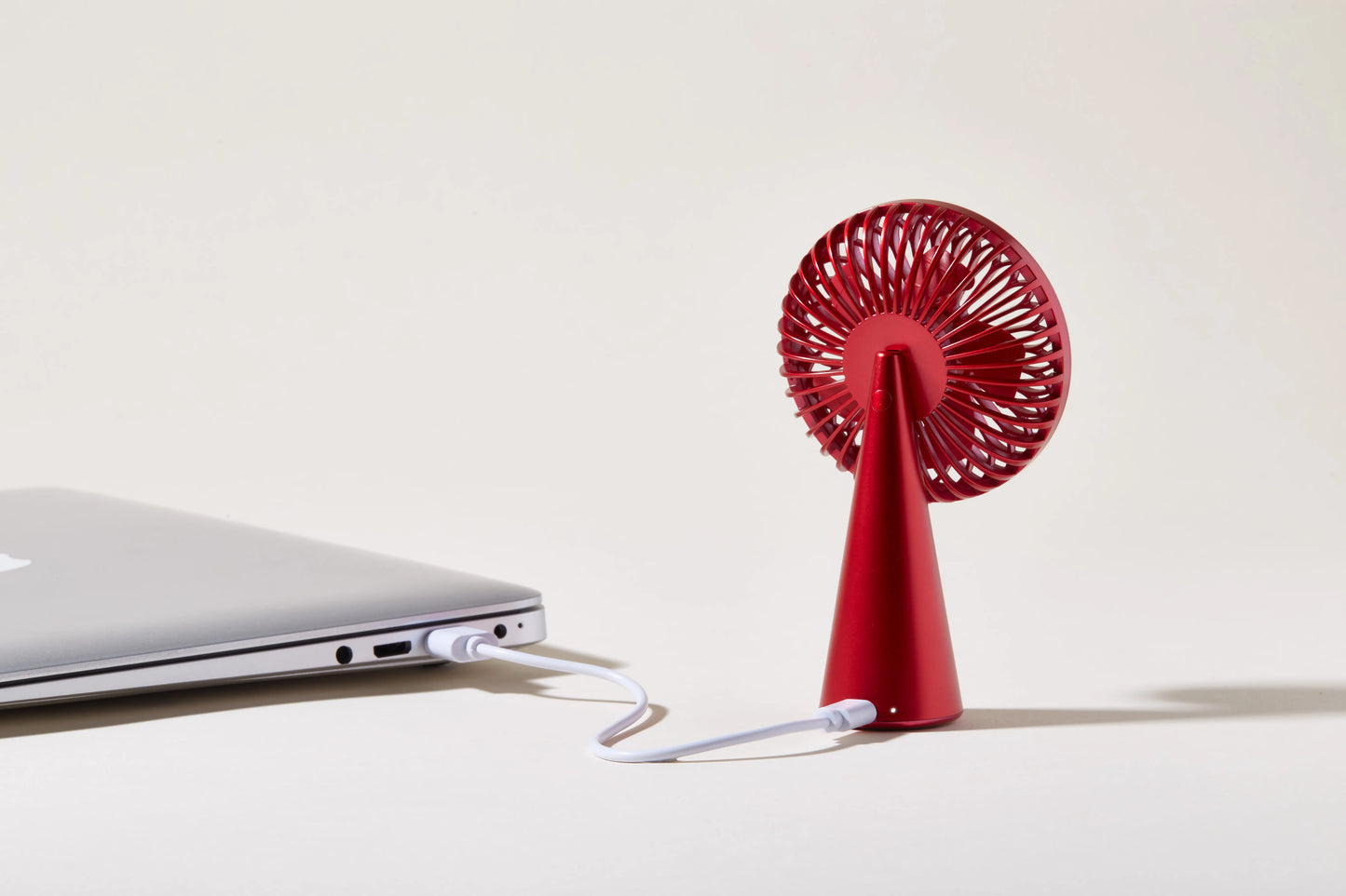 Ventilateur portable rouge Lexon en vue de dos se chargeant à un PC