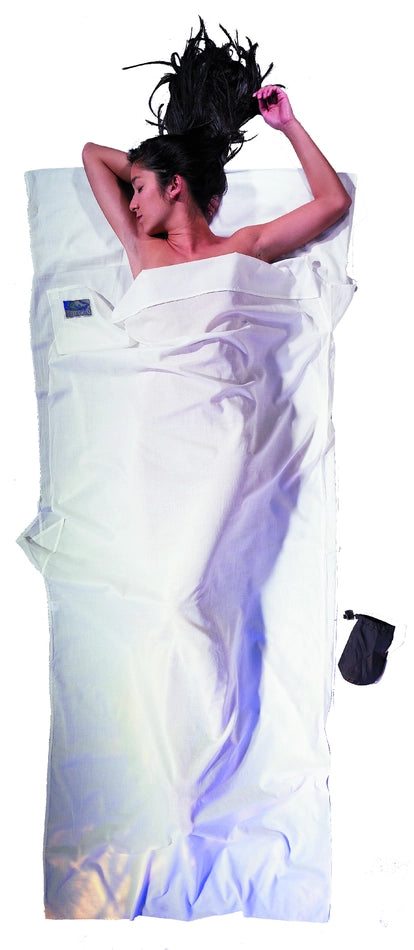 Housse de lit adulte en coton Egyptien de Cocoon – blanc – mise en situation : une personne dort dans le drap, la pochette placée juste à côté.