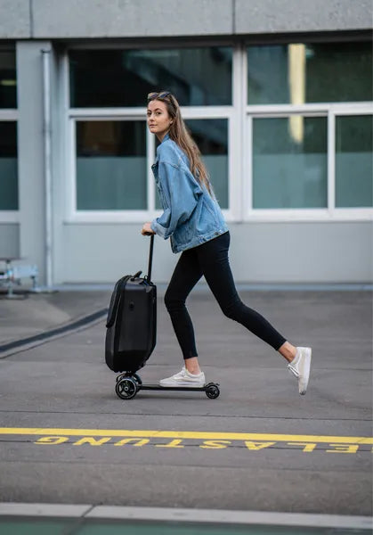 Micromobility micro luggage 4.0 scootcase - Valise trottinette - Mise en situation avec une dame roulant sur la valise trottinette