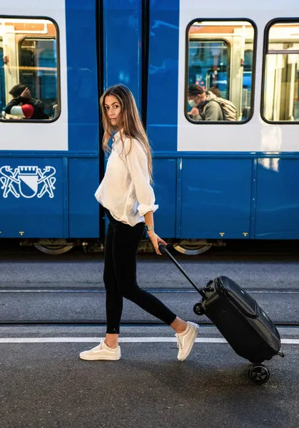 Micromobility micro luggage 4.0 scootcase - Valise trottinette - Mise en situation avec une dame qui tire la valise trottinette devant un wagon de train