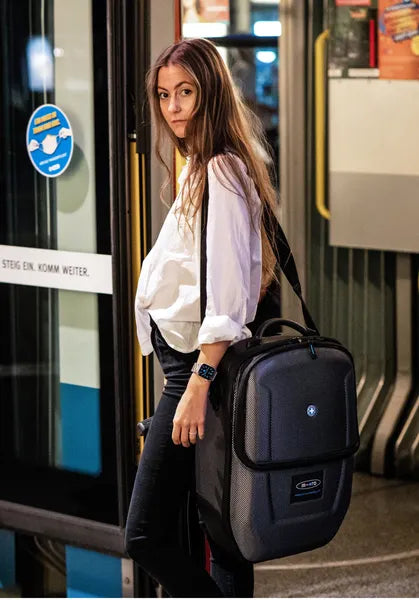 Micromobility micro luggage 4.0 scootcase - Valise trottinette - Mise en situation avec une dame qui porte à l'épaule la valise