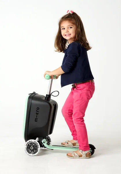 Micromobility Micro Scooter Luggage Junior LED Mint – valise trottinette pour enfants – mise en situation : une fille sur la trottinette, vue de profil