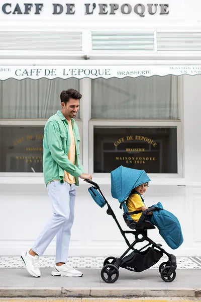 Poussette et chaise haute Micro Trike 360 Plus – Mise en situation avec un enfant dans la poussette, un monsieur qui la pousse