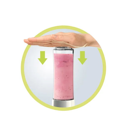 Mini Blender Detoximix – Mise en situation avec une main posée sur la bouteille pour monter qu'il faut appuyer pour enclencher le mécanisme 