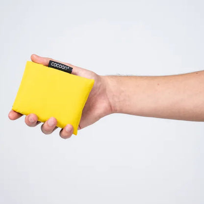 Nappe de pique-nique Cocoon – présentée pliée dans sa pochette, portée à la main.