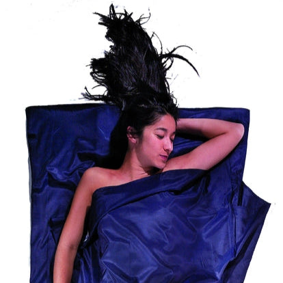 Housse de lit adulte en coton et soie Cocoon - Marine - mise en situation : une personne dort dans le drap, la pochette placée juste à côté.