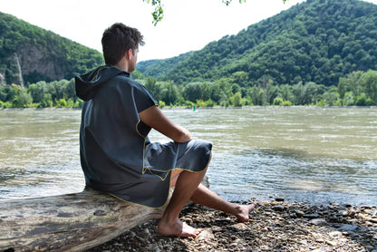 Poncho-serviette unisexe de Cocoon - vue de dos, porté par un homme devant un lac
