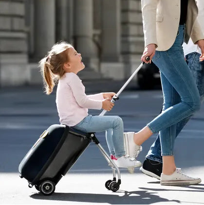 Valise trolley avec siège enfant intégré Micromobility – mise en situation : une femme tire la valise avec une petite fille assise dessus dans la rue